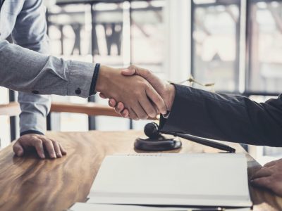 Handshake after good cooperation, Businessman Shaking hands with Professional male lawyer after discussing good deal of contract in courtroom.