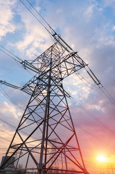 distribution electric substation with power lines and transformers, at sunset
